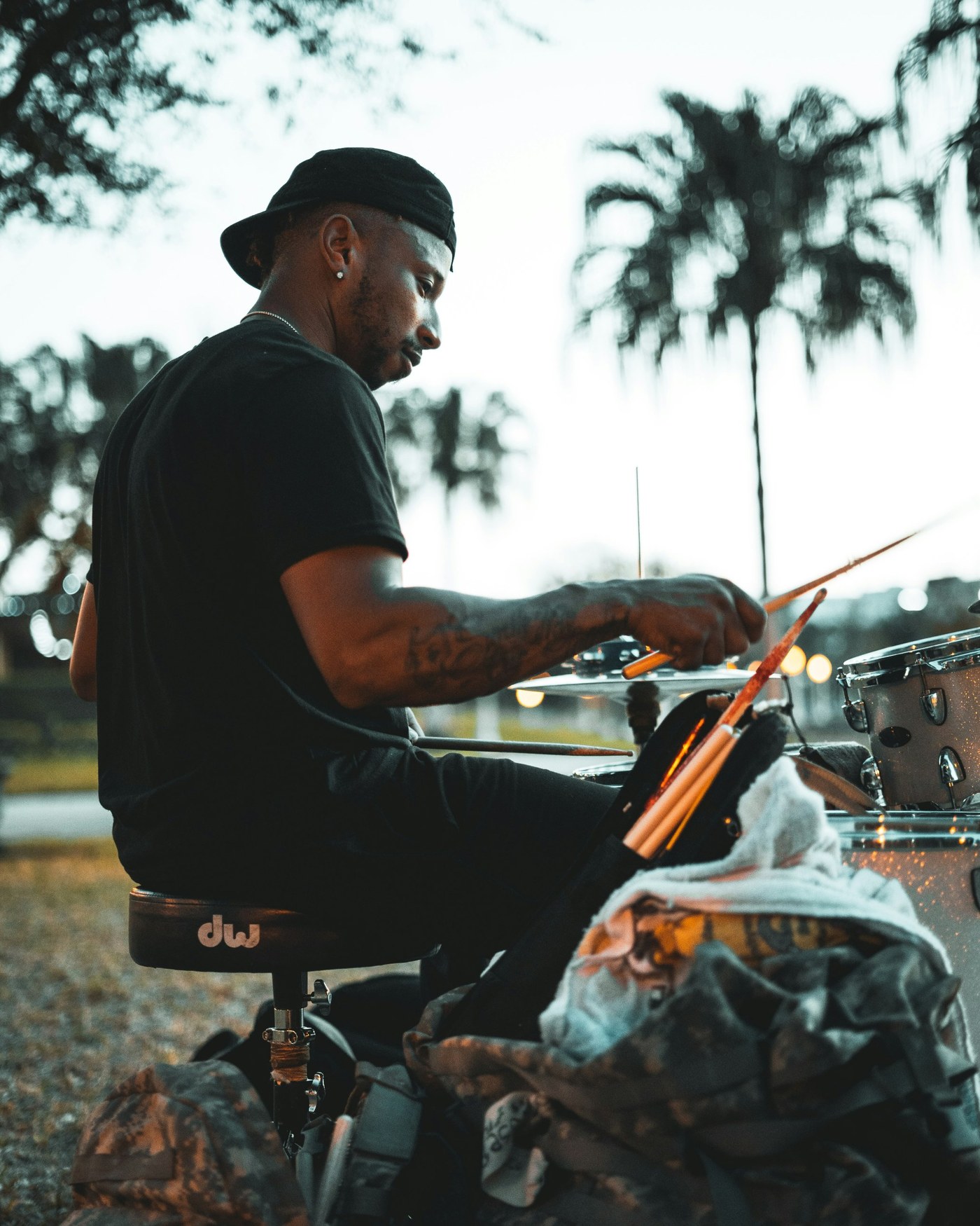A drummer playing an outdoor set at dusk